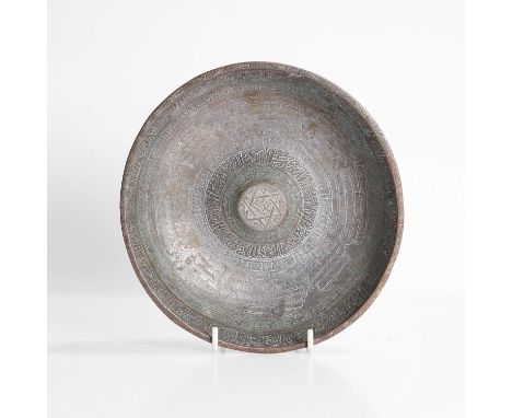 A Persian silvered-brass divination bowl, 19th/20th century, the raised centre with a six-pointed star, densely engraved with