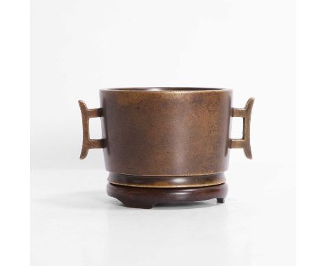 A Chinese bronze incense burner, Qing dynasty (1644-1911), the slightly tapering cylindrical body flanked by two handles cast