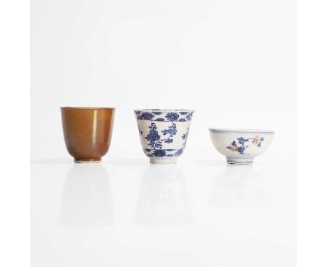 A collection of three Chinese porcelain cups, 18th century, comprising:one blue and white, of lobed form, painted with sprigs