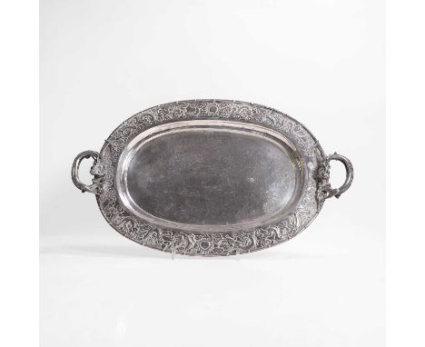 A Chinese silver two-handled tray, 19th century, of oval form on four ball feet, the centre chased with phoenixes amongst peo
