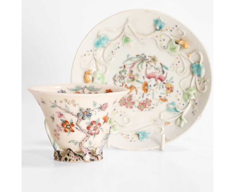 A Chinese blanc de Chine libation cup, 18th century, of rhinoceros form, moulded with a blossoming prunus tree, the reverse w