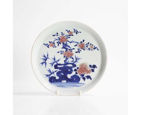 A Chinese copper-red and underglaze blue plate, Qianlong (1736-1795), of circular form, painted with peony, prunus and bamboo