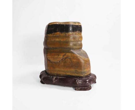 A Chinese scholar's rock, 20th century, of irregular form, the stone of dark grey, amber and green tone,25cm high, wood stand