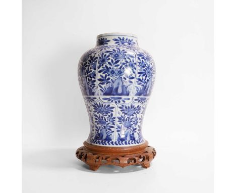 A Chinese blue and white vase, Kangxi (1662-1722), of baluster form, painted with florets and rocks in shaped panels, 27cm hi