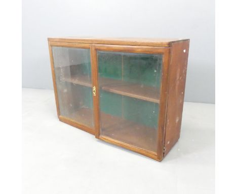 A mid century teak tabletop display cabinet, with two glazed doors and single adjustable shelf. 84x60x26cm.Locked, key broken