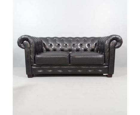 A black button back faux-leather upholstered two seater Chesterfield sofa. Overall 188x80x90cm, seat 120x43x58cm. 