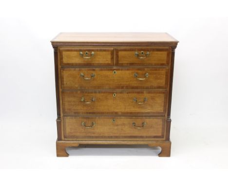 George III oak and fruitwood crossbanded chest of drawers, two short over three long drawers between fluted columns, on brack