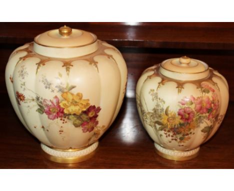 Two graduated Royal Worcester blush ivory vases and covers of melon form with floral painted decoration, the larger 27cm high