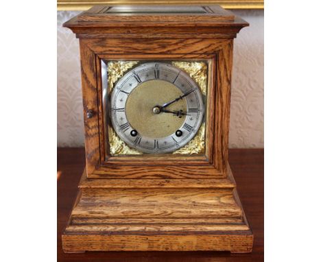 Edwardian oak cased mantel clock of square form with brass dial and twin chain movement striking on a gong, 30cm high 