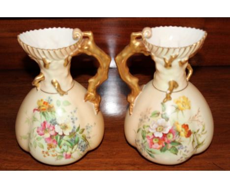 Pair of Royal Worcester blush ivory jugs of squat form with floral sprays and branch-work handles, 19cm high 