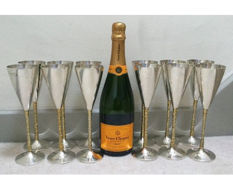 STUART DEVLIN: A rare set of twelve silver and silver gilt tapering champagne flutes with textured stems to spreading bases. 