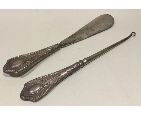 A pair of silver mounted button hooks / shoe horns. Est. £10 - £20.