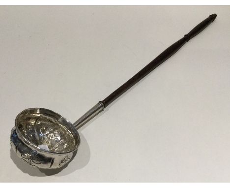 A good Georgian chased silver toddy ladle with turned wooden handle. Approx. 46 grams. Est. £60 - £80.