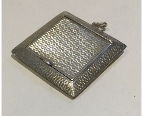 A heavy engine turned silver compact of stylised form. London. Approx. 25 grams. Est. £25 - £35.
