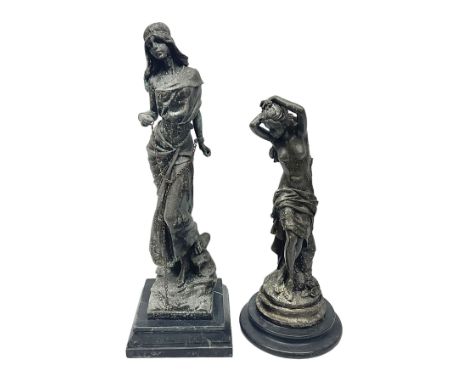 Two bronzed figures, the first modelled as a woman in chains, the second semi nude female with her arms raised above her head
