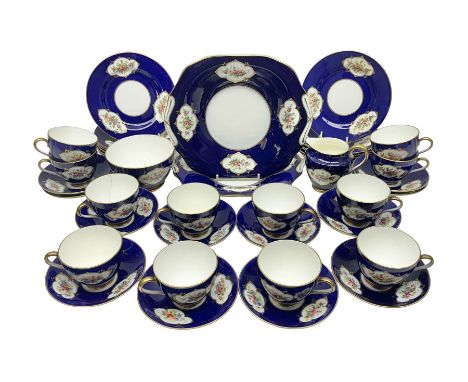 Crown Chelsea tea service for twelves, decorated with panels of floral sprigs, with a blue ground, comprising tea cups and sa