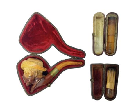 Carved Meerschaum pipe, depicting a man in a hat, with amber mouth piece, together with two cheroot holders, all within toole