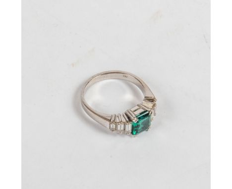 Smaragd-Diamant-Ring750 er Weißgold. Glatte Ringschiene, Schulter mit je drei Diamant-Baguett besetzt,  Ringkopf mit rechteck