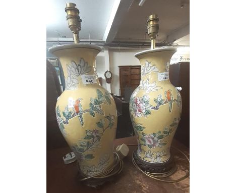 Pair of Chinese yellow ground baluster vases, now converted to lamp bases on hardwood stands decorated with exotic birds amon