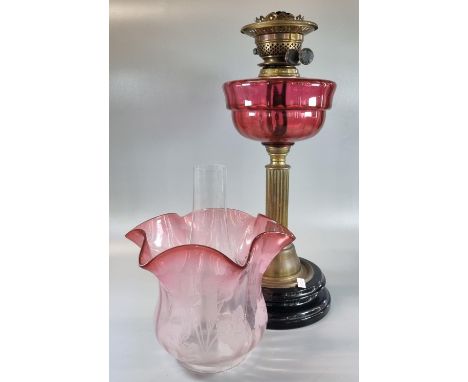 Early 20th Century double oil burner lamp, having cranberry etched glass foliate shade above a cranberry reservoir on a Corin