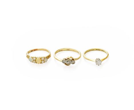 An Opal and Diamond Ring, three graduated oval cabochon opals spaced by pairs of old cut diamonds, in yellow claw settings, t