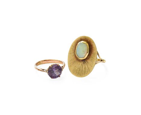 An Opal Ring, the yellow textured oval plaque decorated with an oval cabochon opal, stamped '9CT', finger size I (a.f.); and 