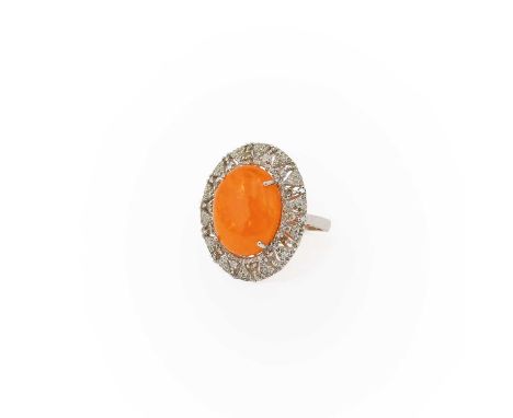 An Opal and Diamond Cluster Ring, the oval opal cabochon in a four claw setting, within a stepped border of round brilliant a