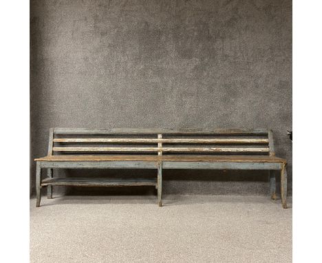 A 19th century painted and distressed French provincial hall bench in pale blue and white  having a long moulded and slatted 