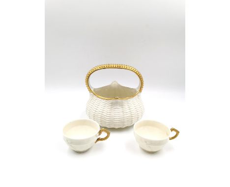 A 19th century Royal Worcester simulated weave basket with a gilt handle, along with two Royal Worcester coffee cups with gil