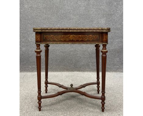 A French Louis XVI style kingwood card table having a marquetry inlaid fold-over top with lobed corners and a revolving actio