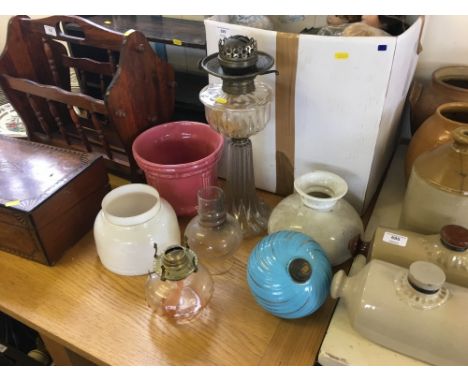 An oil lamp and various glass shades 