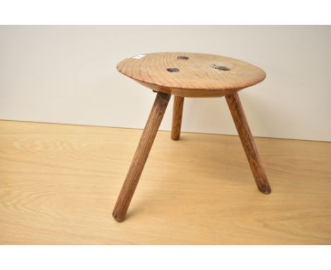 A 19th century primitive elm tripod milking stool, h24cm.