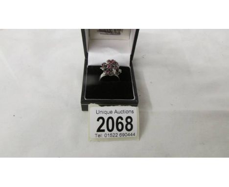 A ruby set ring circa 1960/70's in a cluster style with a white metal shank, size L.