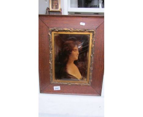 An oak framed Victorian cristolian featuring a portrait of a lady.