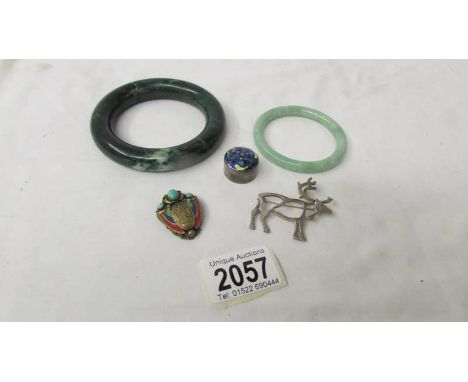 A jade bangle, another bangle, a silver deer brooch, an enamel silver box and an unusual dress clip in art deco style.