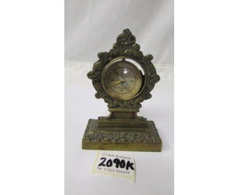 An old brass pocket watch stand and a compass.