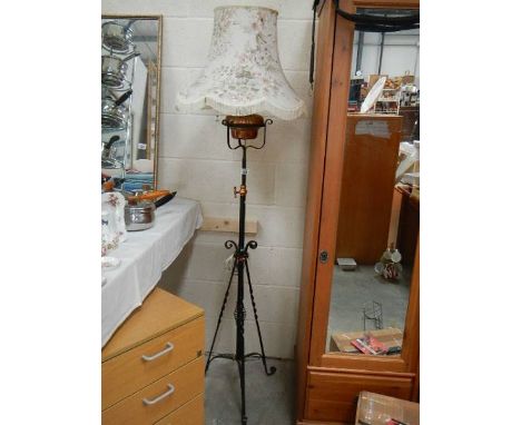 An early 20th century wrought iron adjustable standard oil lamp converted to electric.