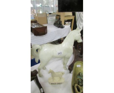 A White Horse Scotch whisky horse and a plastic white horse.