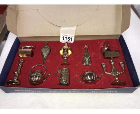 A vintage box set of brass miniatures of gramophone, oil lamp &amp; violin bellows etc.
