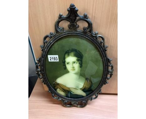 An oval metal framed portrait of a lady. (glass A/F)
