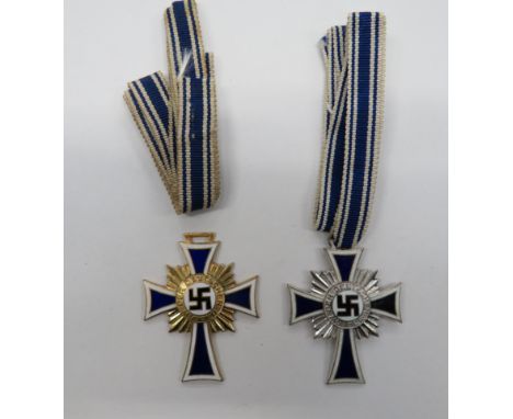 German Third Reich. 1st and 2nd Class Mothers CrossesA gilt example and a silvered example in blue and white enamel with cent