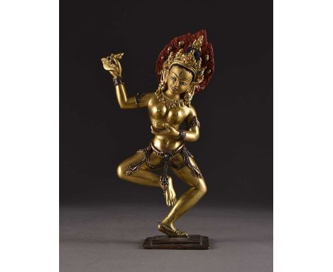 A Tibetan gilt bronze figure of a Dakini, 20th centuryModelled in dancing pose with one arm raised, her body adorned with bea