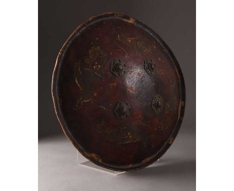 A painted hide leather shield or Dhal, Northern India, 19th centuryOf domed form with everted rim, having four cast metal mas