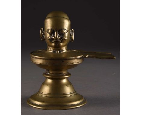 A bronze Shiva lingam, India, 18th/19th centuryThe head of Shiva with long pierced earlobes, set on a Yoni base with domed fo
