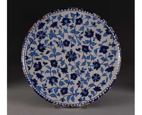 A Multan tin glazed earthenware circular dish, 19th centuryPainted with blue and turquoise flowers on a white ground. 36cm di