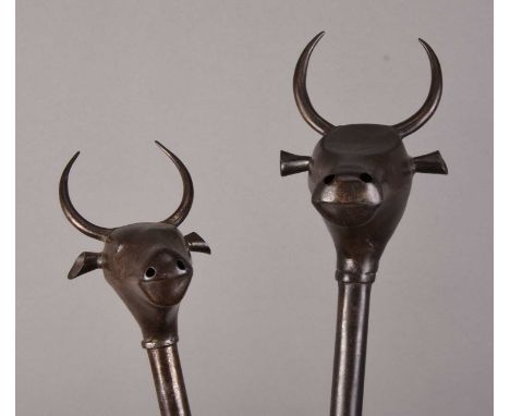 Two Persian bull's head maces, Qajar Dynasty, 19th centuryEach with a two-part bull's head finial on a straight shaft with ro