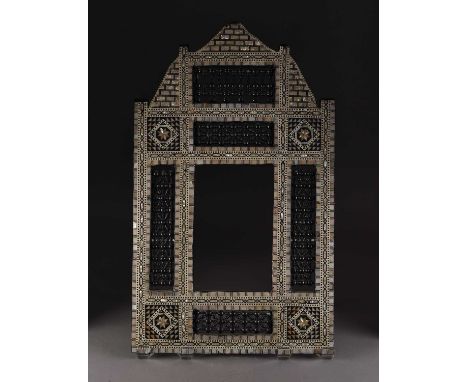 An Egyptian Mashrabiya inlaid mirror frameEarly 20th century, of arched form and inlaid with bone and mother-of-pearl, inset 