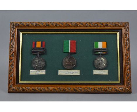 A SMALL GLAZED FRAME CONTAINING THREE MEDALS, which are plaster/plastic reproductions, however two of the medals have been na
