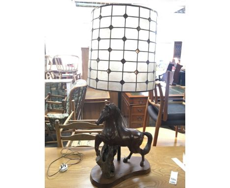 A large carved hardwood lamp in the form of a horse with detachable shade.