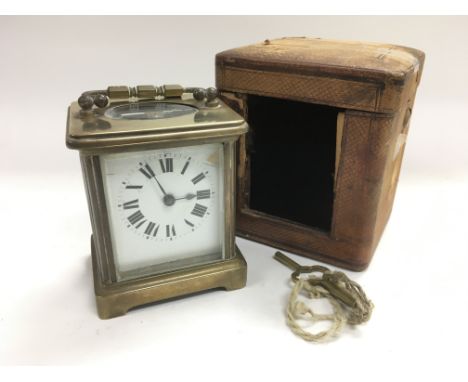 A brass cased carriage clock with original outer travel case and key.